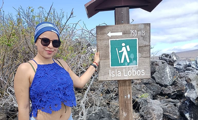 Tourist next to the sign that starts the trail on the Isla Lobos Tour, San Cristobal Galapagos